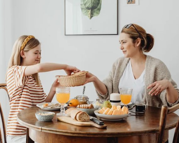 A warm family breakfast with mother and daughter sharing a meal in a cozy dining area.